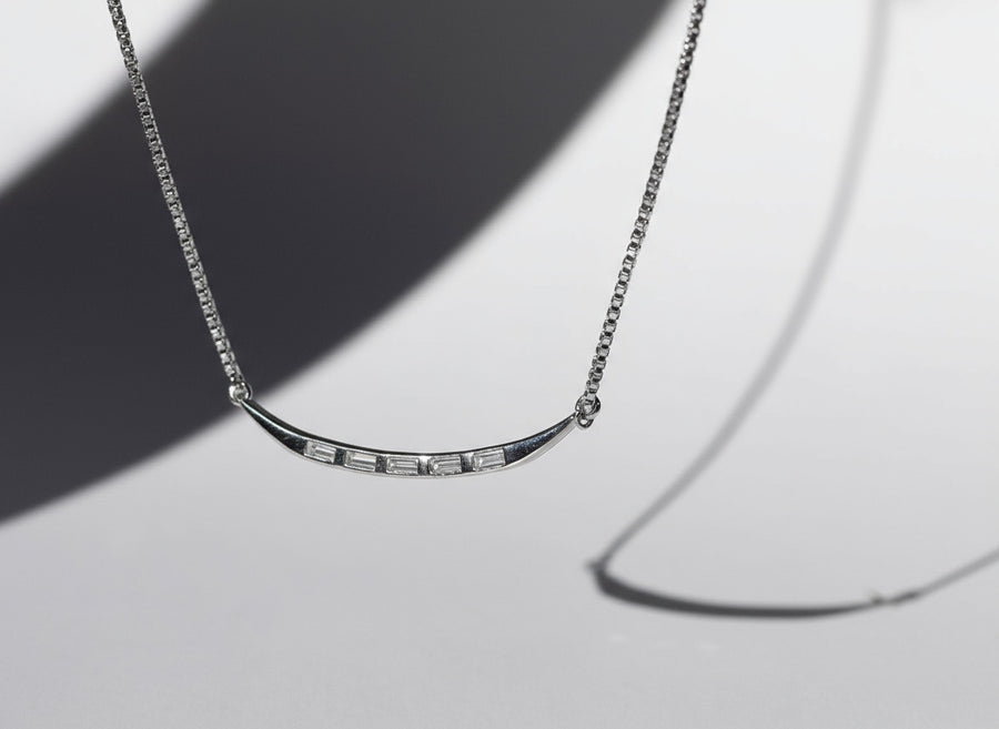 Silver necklace with a subtle design on a light gray background