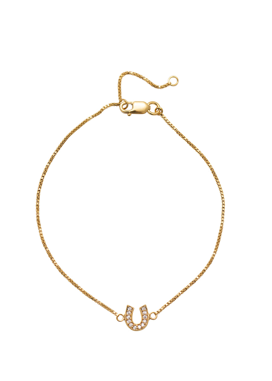 Gold bracelet with horseshoe charm on a white background