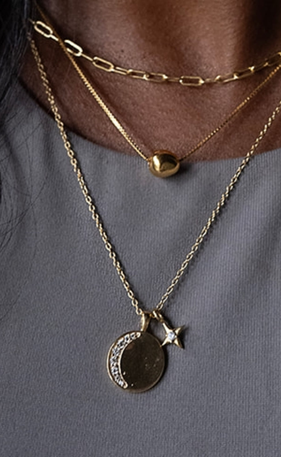 three gold necklaces on a model