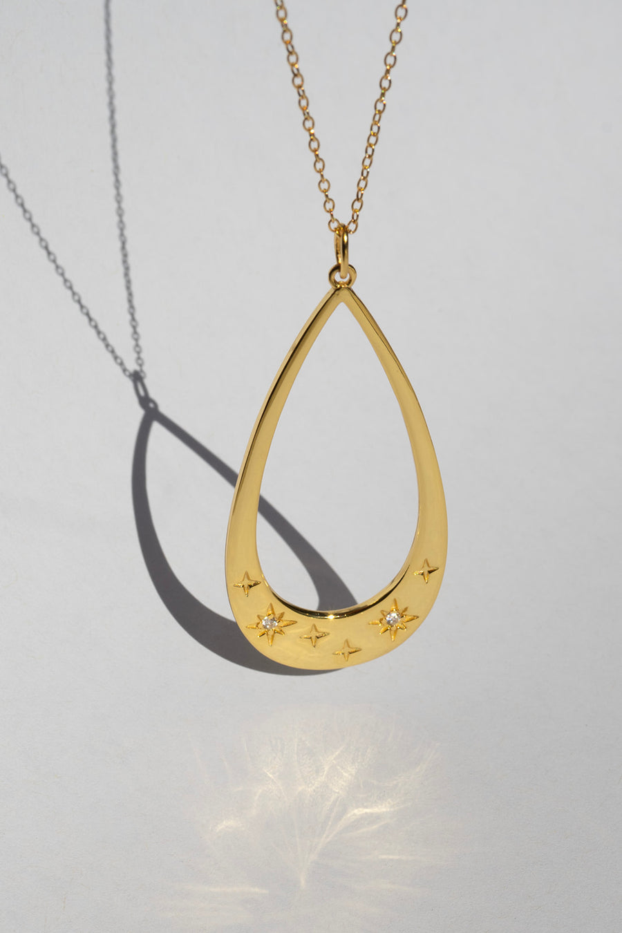 gold teardrop necklace on grey backdrop