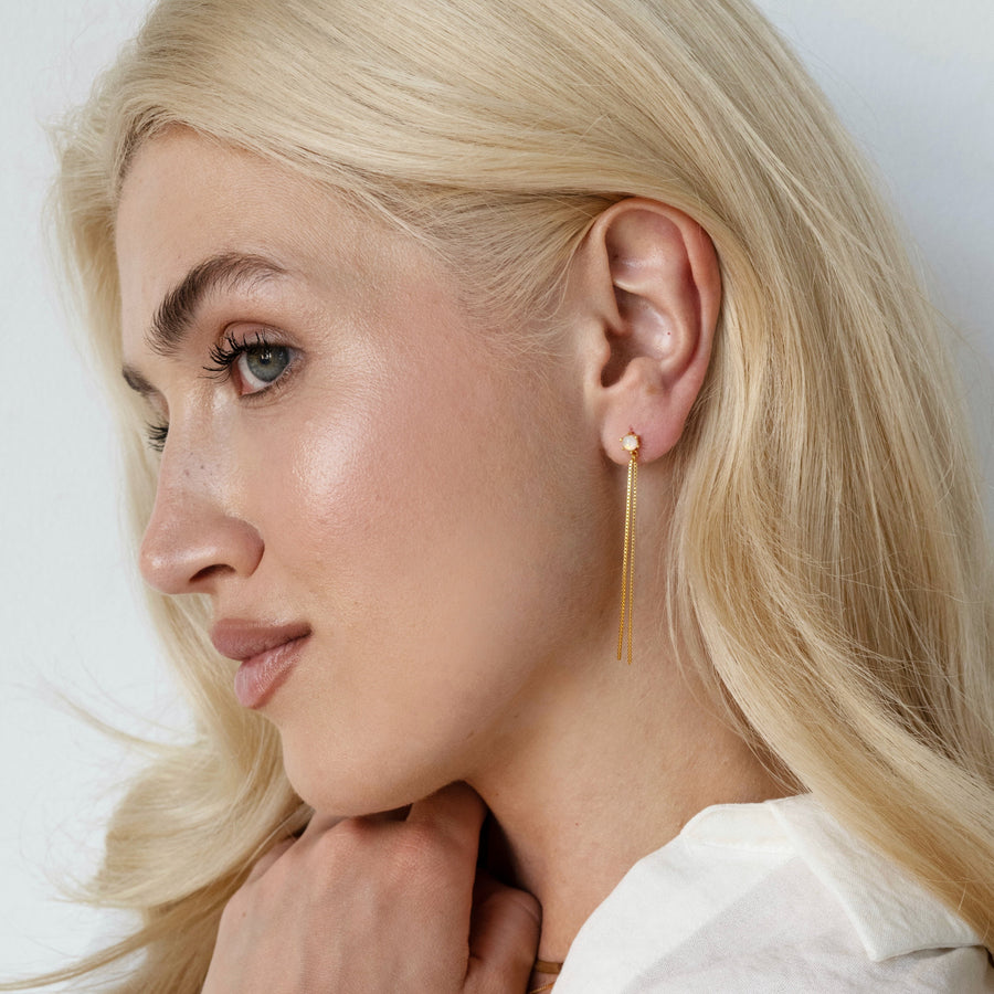 Woman with blonde hair wearing a white shirt against a light background