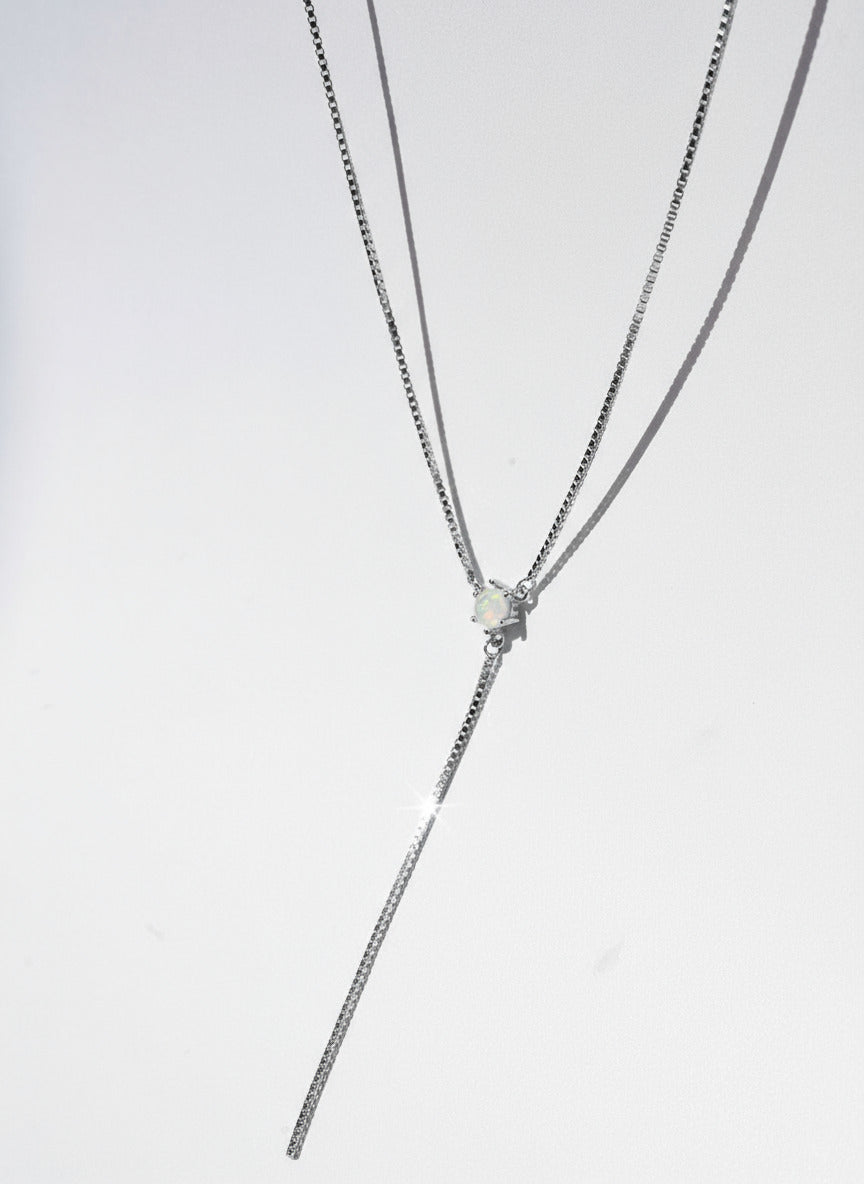 silver necklace with a small pendant on a white background