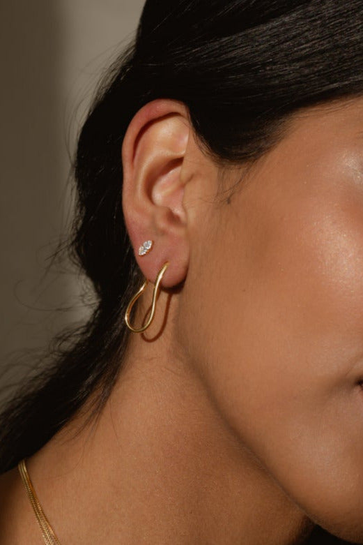 a models ear wearing two different earrings