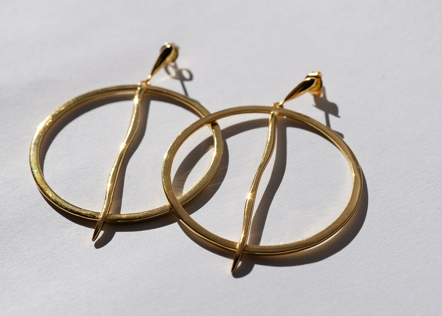 Gold hoop earrings on a light gray background