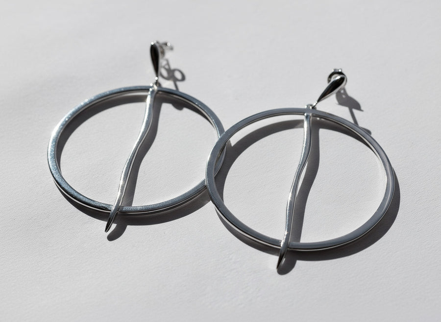 Silver hoop earrings on a light gray background