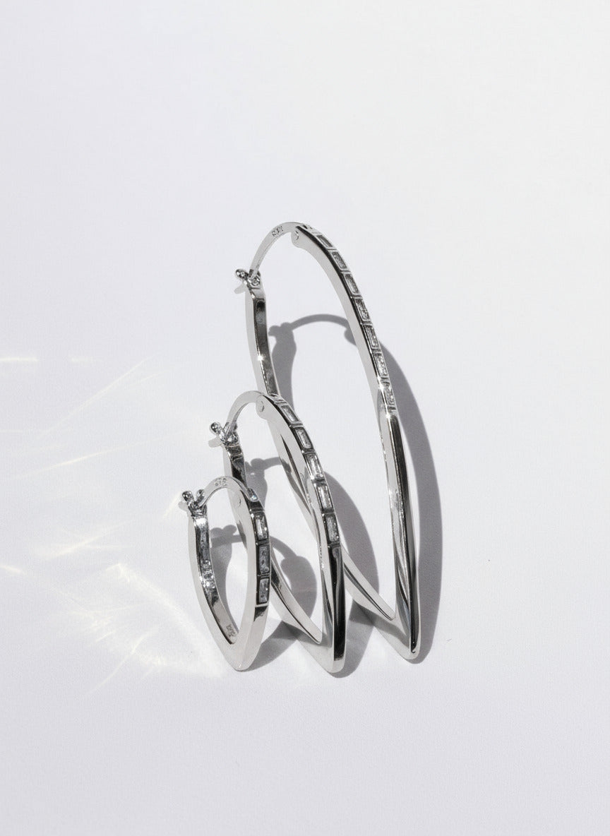 Silver hoop earrings on a light gray background