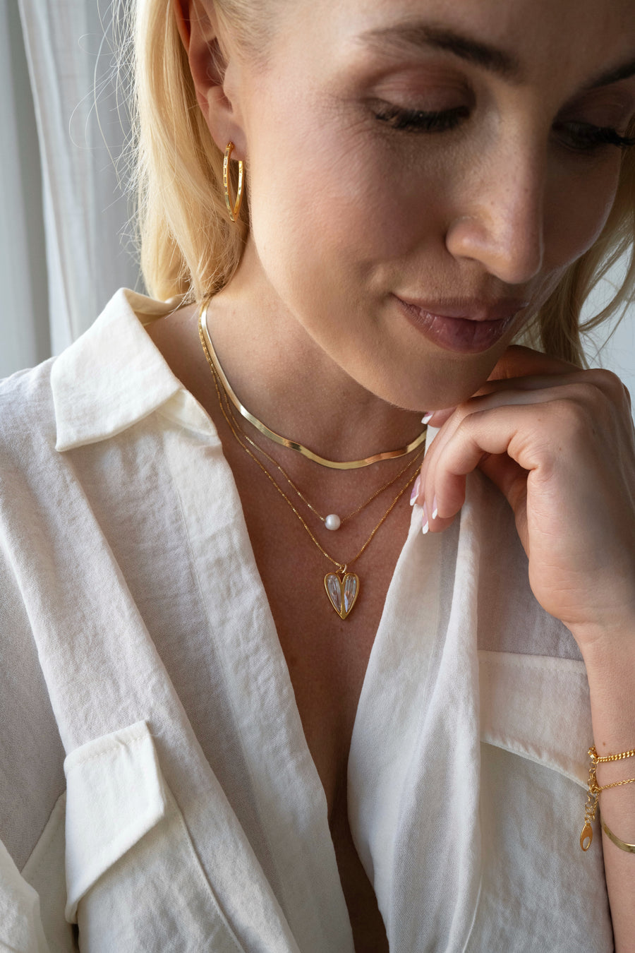 woman wearing a layer of gold neckalce