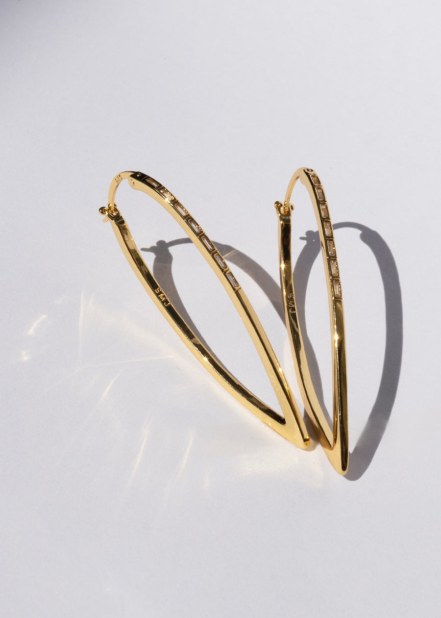 Gold hoop earrings on a light gray background