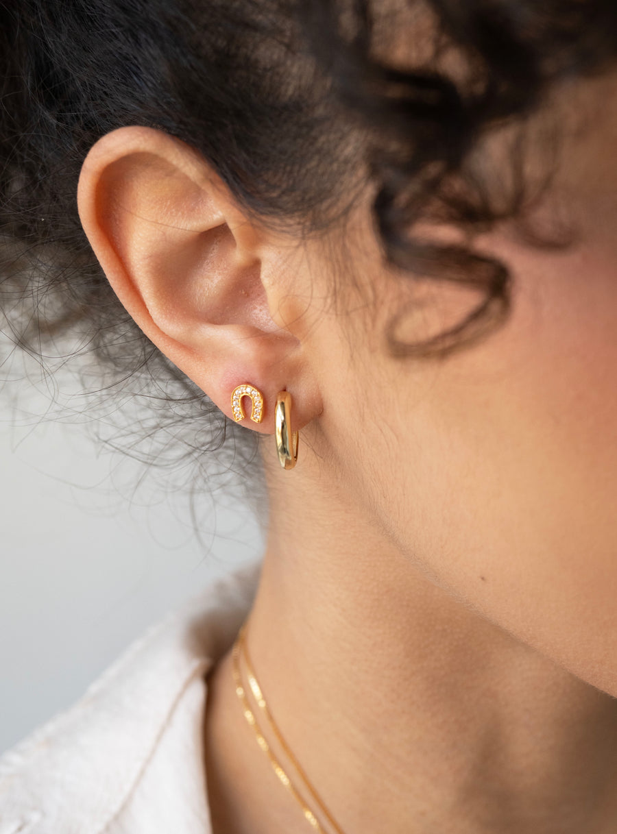 Model wearing 2 layers of gold earrings