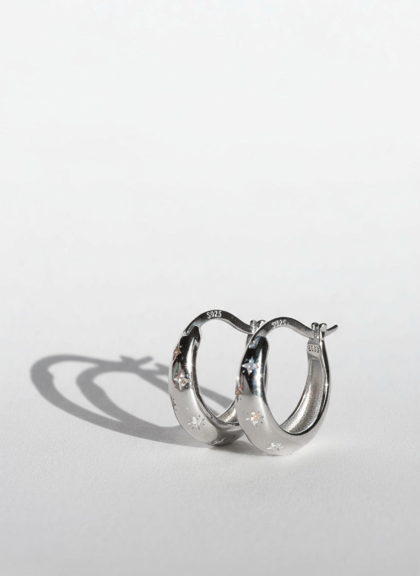 Silver hoop earrings on a light gray background