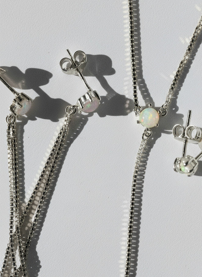 Gold jewelry set with necklace and earrings on a light gray background