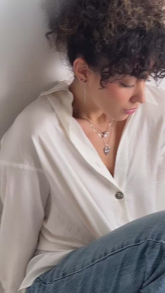 A model wearing layers of sterling silver jewelry