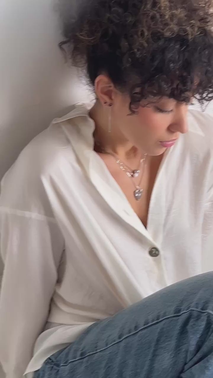 A model wearing layers of sterling silver jewelry