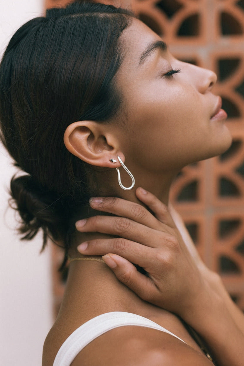 Woman wearing a silver earring with a blurred background