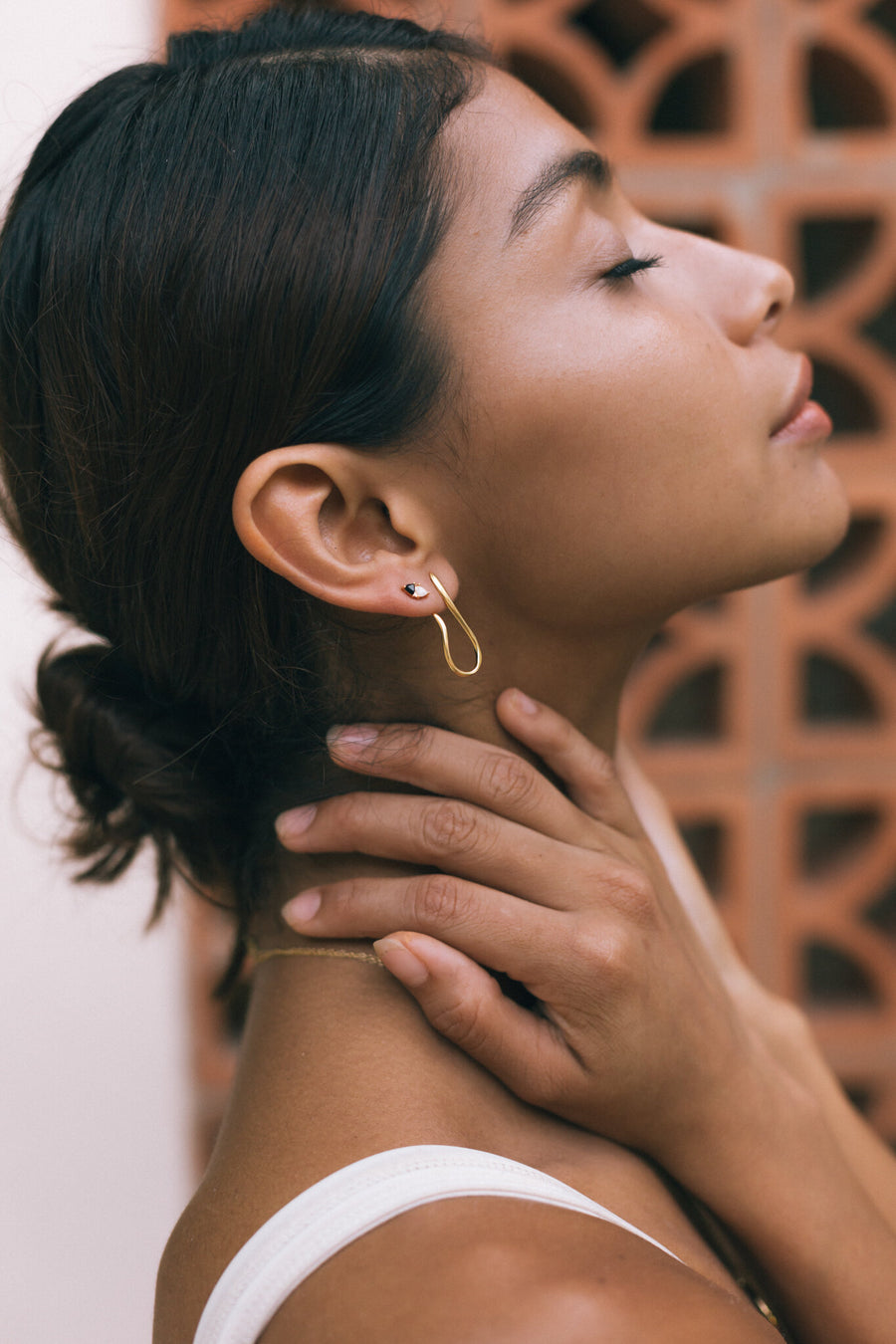 woman standing with her profile to the side wearing statement earrings 
