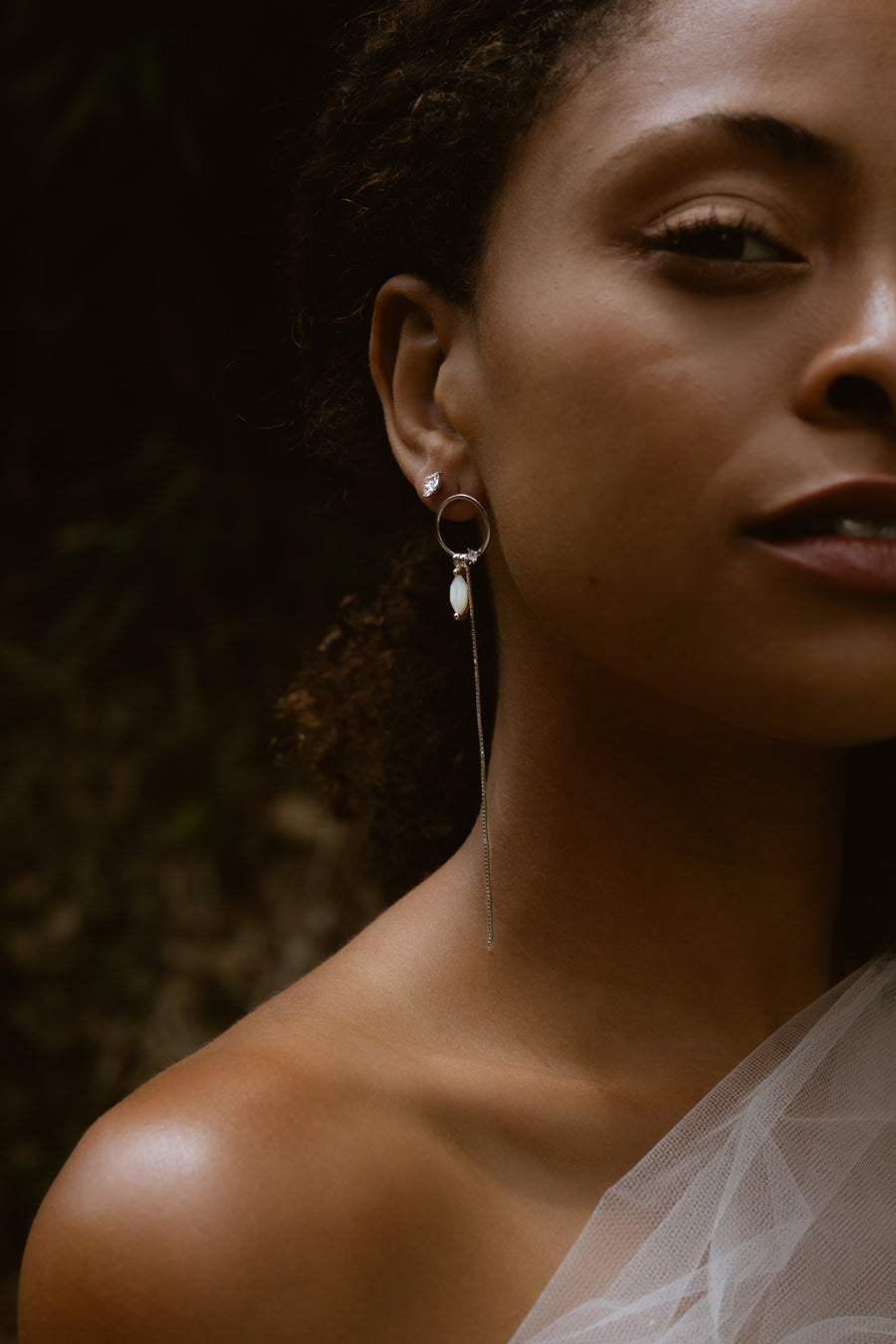 woman looking at camera wearing earrings 